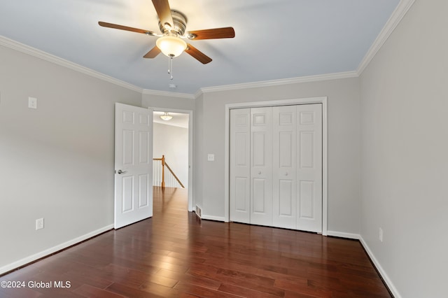 unfurnished bedroom featuring ceiling fan, dark hardwood / wood-style flooring, ornamental molding, and a closet