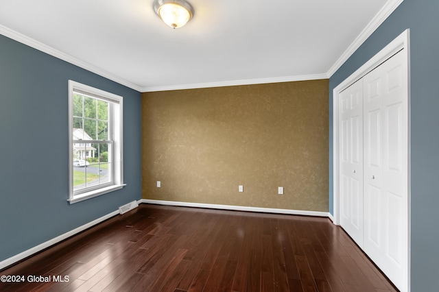 unfurnished bedroom with dark hardwood / wood-style floors, a closet, and ornamental molding