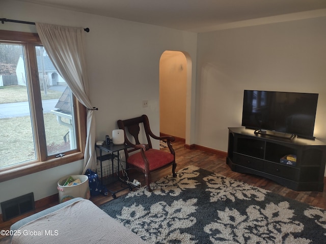 sitting room with plenty of natural light and dark hardwood / wood-style floors