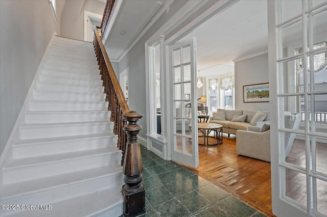 stairs featuring ornamental molding and french doors