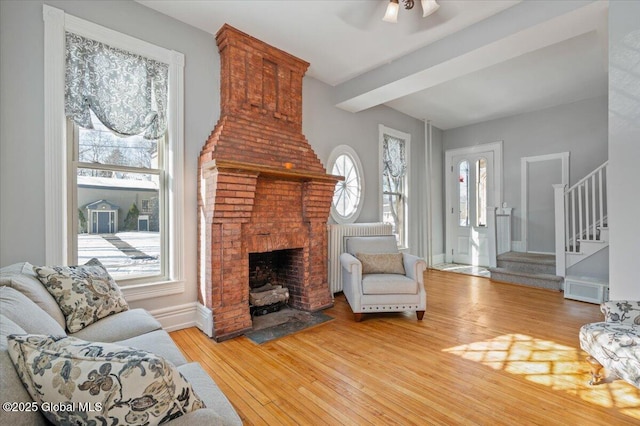 living room with hardwood / wood-style floors, a fireplace, a healthy amount of sunlight, and ceiling fan