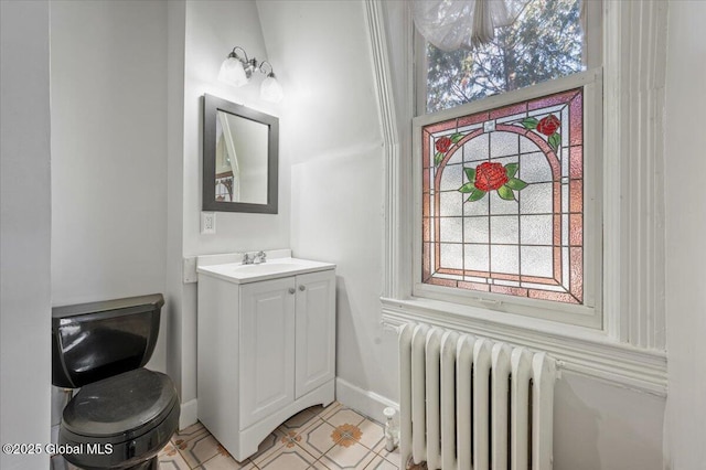 bathroom with tile patterned flooring, vanity, radiator heating unit, and toilet