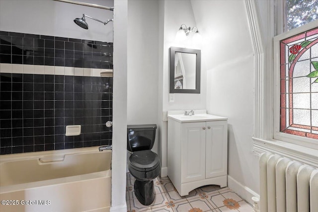 full bathroom featuring tile patterned floors, toilet, radiator heating unit, vanity, and tiled shower / bath combo