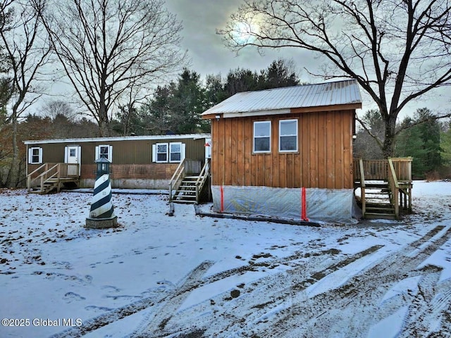 view of snow covered back of property