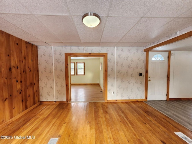 interior space featuring a drop ceiling and wood-type flooring