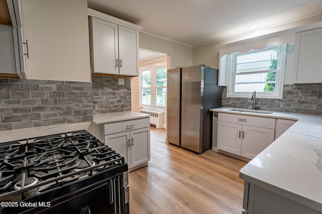 29 Lockrow Blvd, Colonie, NY 12205 - kitchen with freestanding refrigerator, black gas stove, radiator, tasteful backsplash, and light wood finished floors
