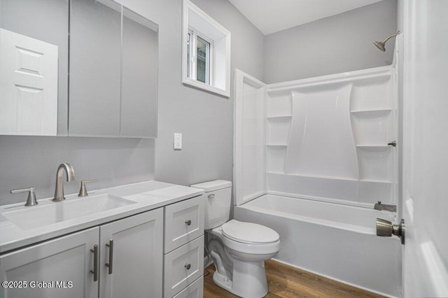 full bathroom featuring toilet, hardwood / wood-style floors, vanity, and washtub / shower combination