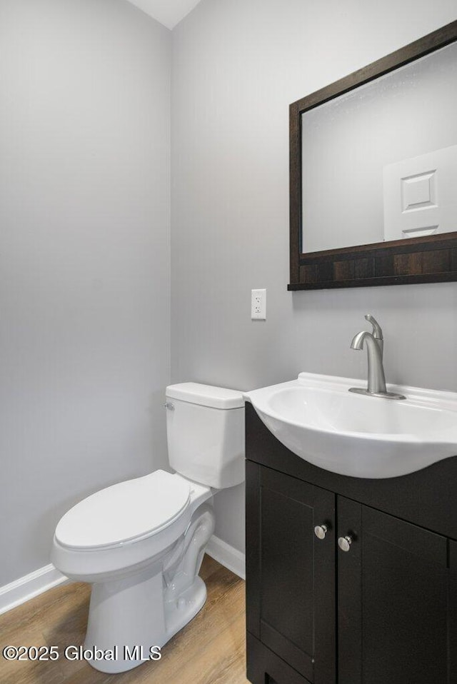 bathroom featuring wood-type flooring, vanity, and toilet