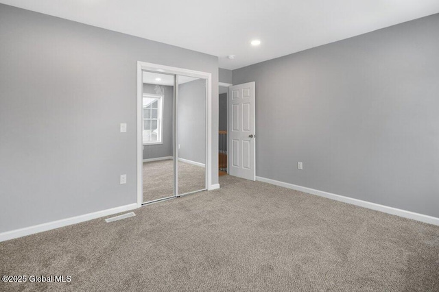 unfurnished bedroom featuring carpet and a closet