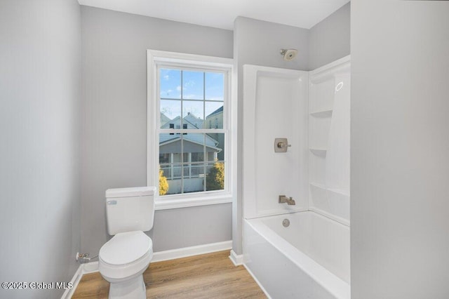 bathroom with shower / tub combination, hardwood / wood-style floors, and toilet