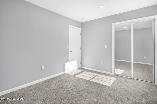 unfurnished bedroom featuring light colored carpet and a closet