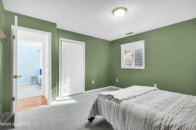 bedroom with carpet floors and a textured ceiling