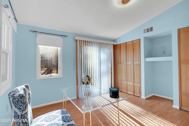 interior space featuring hardwood / wood-style floors and vaulted ceiling