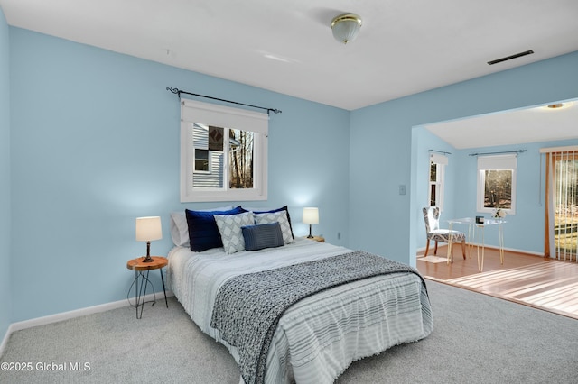 carpeted bedroom featuring multiple windows