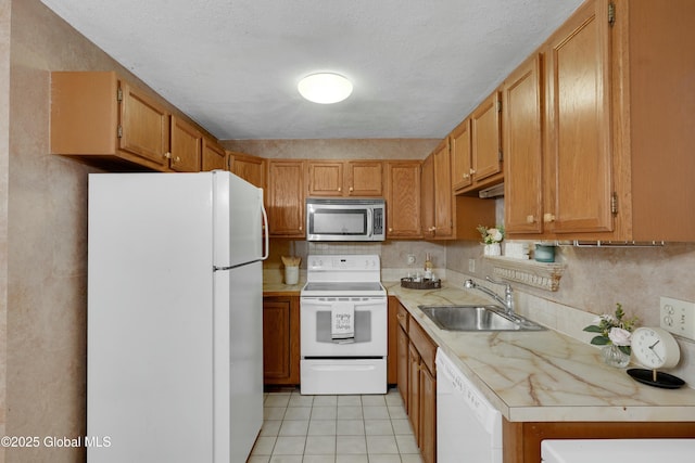 kitchen featuring light tile patterned floors, white appliances, a textured ceiling, and sink