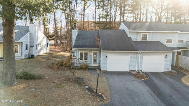 view of front of home with central AC unit and a garage