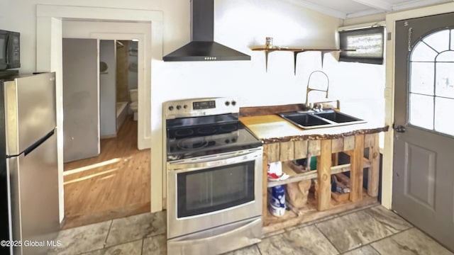 kitchen featuring sink, wall chimney range hood, ornamental molding, and stainless steel appliances