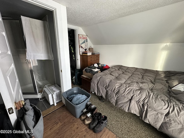 bedroom featuring a textured ceiling, a closet, lofted ceiling, and dark wood-type flooring