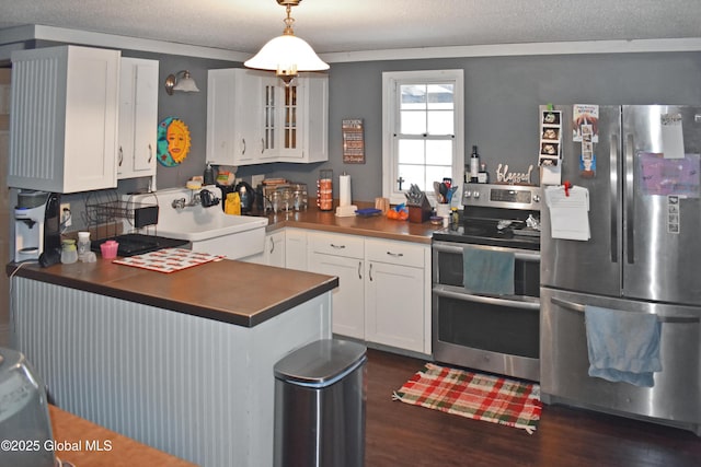 kitchen with kitchen peninsula, white cabinetry, stainless steel appliances, and hanging light fixtures