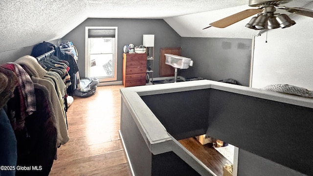 office with ceiling fan, vaulted ceiling, a textured ceiling, and light hardwood / wood-style flooring