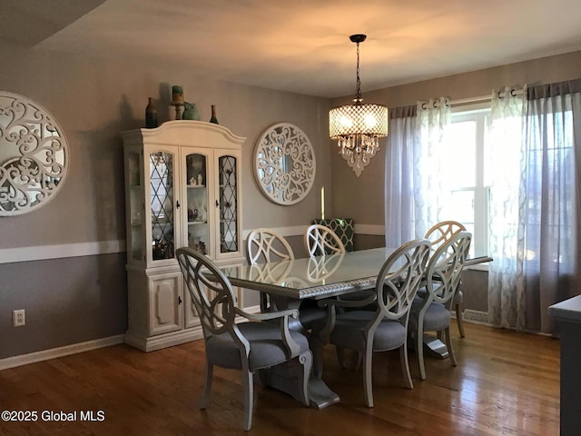 dining space with a chandelier and dark hardwood / wood-style flooring