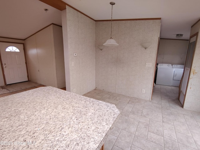 kitchen with washer and clothes dryer, crown molding, and hanging light fixtures