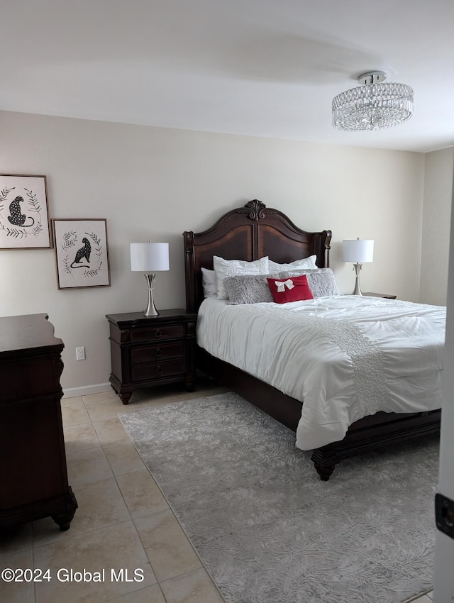 tiled bedroom with an inviting chandelier