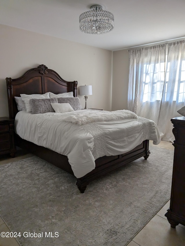 tiled bedroom with a chandelier