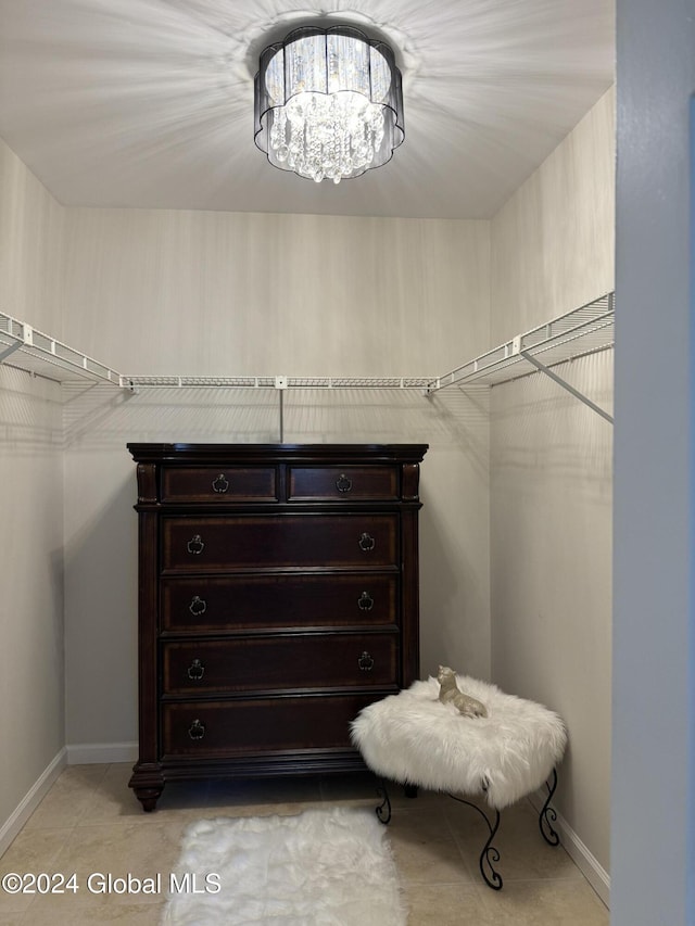 spacious closet with an inviting chandelier and light tile patterned flooring