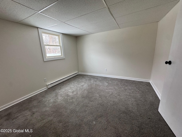 spare room with a paneled ceiling, baseboards, dark carpet, and baseboard heating