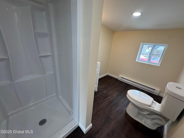 bathroom featuring a stall shower, baseboards, toilet, wood finished floors, and a baseboard heating unit