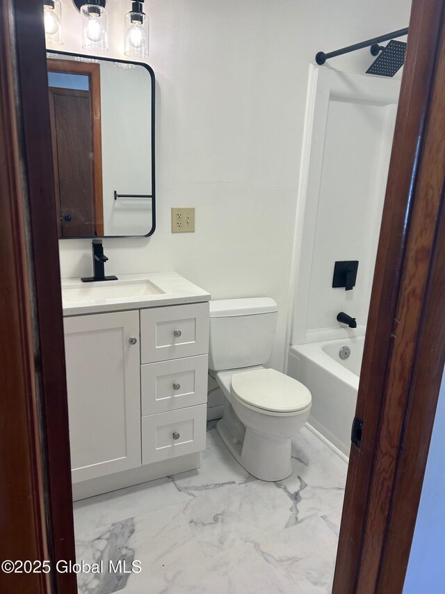 bathroom with marble finish floor, vanity, bathing tub / shower combination, and toilet