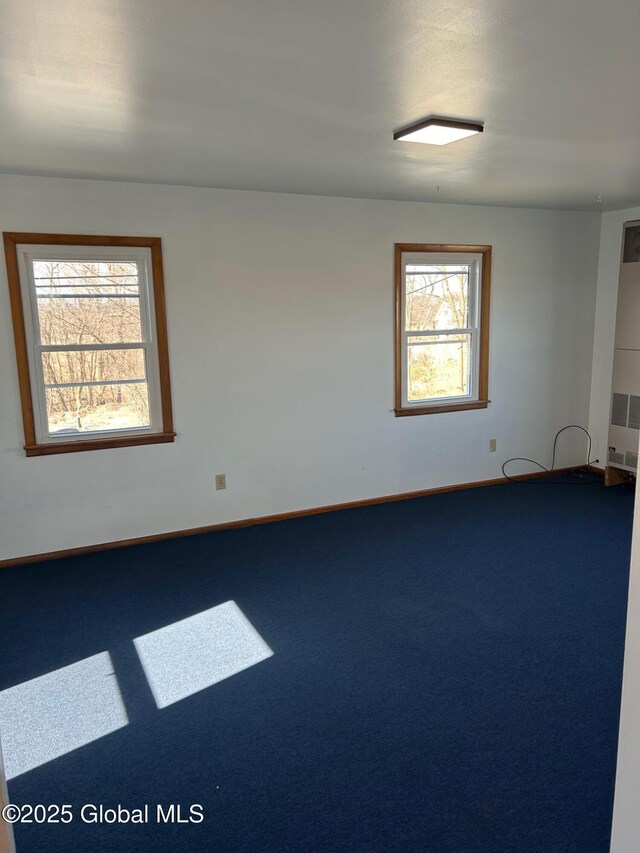 spare room featuring carpet flooring and baseboards