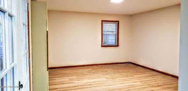 empty room with light wood finished floors and baseboards