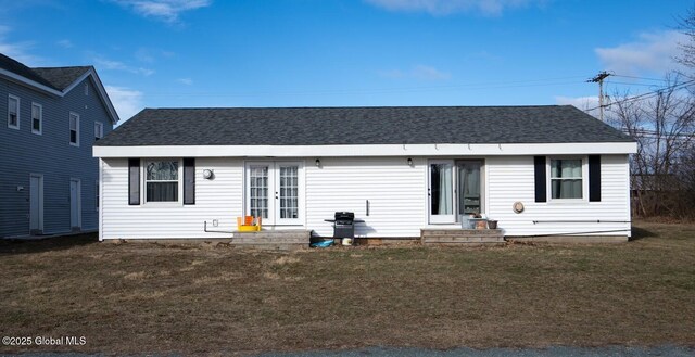 view of front of house with french doors, roof with shingles, a front yard, and entry steps