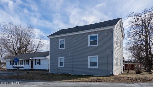 exterior space featuring a shingled roof