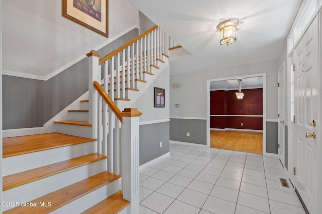 tiled foyer entrance with ornamental molding