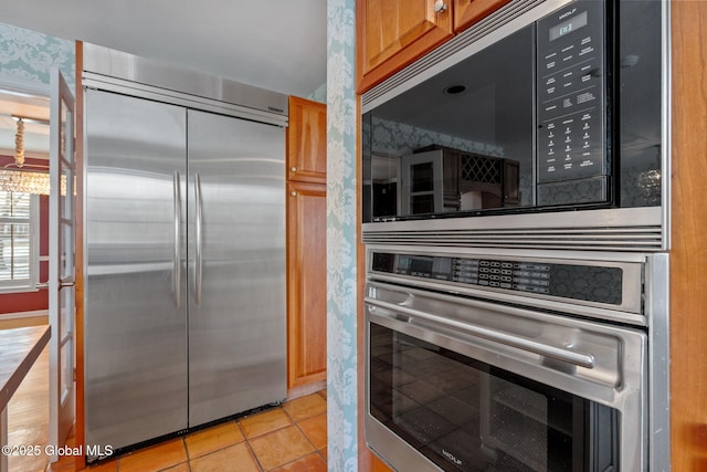 kitchen with stainless steel appliances and light tile patterned flooring