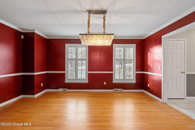 unfurnished room with hardwood / wood-style flooring, a wealth of natural light, crown molding, and a notable chandelier