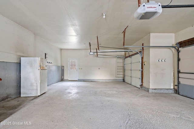 garage with a garage door opener and white refrigerator