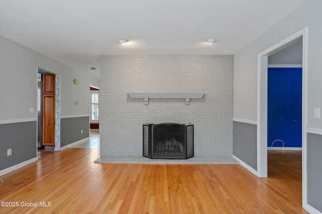 unfurnished living room with a fireplace and light hardwood / wood-style flooring