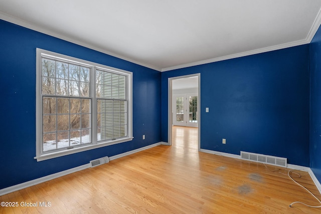 spare room with ornamental molding, french doors, and light wood-type flooring