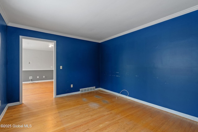 empty room with ornamental molding and hardwood / wood-style floors