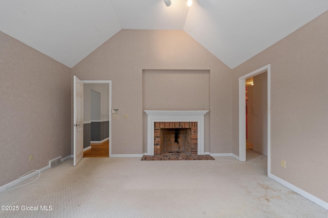 unfurnished living room with lofted ceiling, a fireplace, and carpet flooring