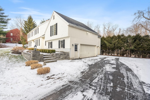 snow covered property with a garage