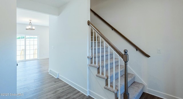 staircase with hardwood / wood-style flooring