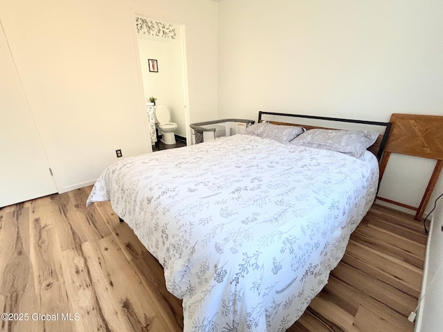 bedroom with hardwood / wood-style floors and connected bathroom