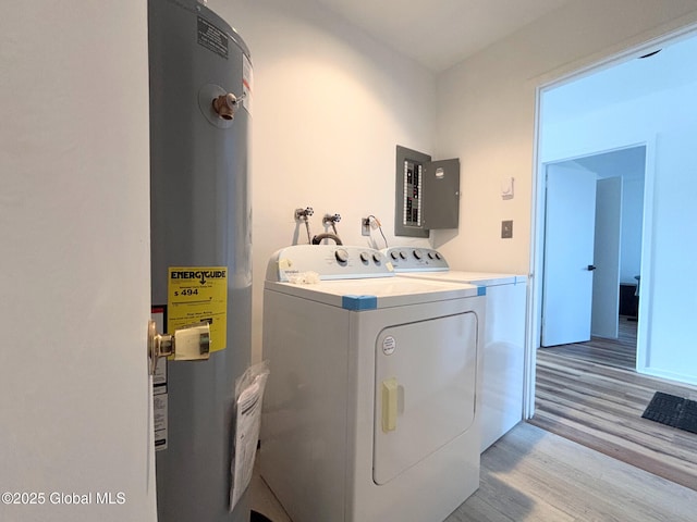 laundry area featuring washing machine and dryer, water heater, electric panel, and light hardwood / wood-style flooring