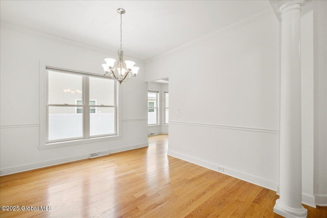 unfurnished dining area featuring ornate columns, a chandelier, hardwood / wood-style flooring, and crown molding