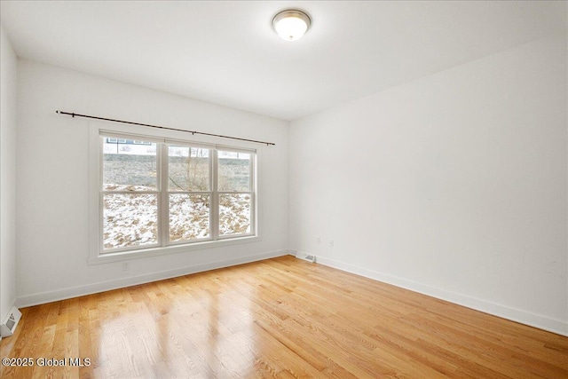 empty room with light hardwood / wood-style flooring